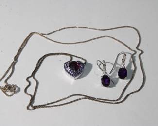 .925 Sterling Suite with Heart Shaped Amethyst Pendant and chain long with pierced earrings with oval prong set amethyst both pendant and earrings are accented with clear gems, total weight for all items is 8.6 grams, chain is approx 30" long