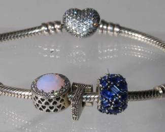 .925 Sterling Silver Designer Pandora Bracelet with three .925 hallmarked Pandora charms to include opal charms number 1 charm and blue gemstone charm total weight is 20.6 grams ending in hallmarked Pandora Heart clasp