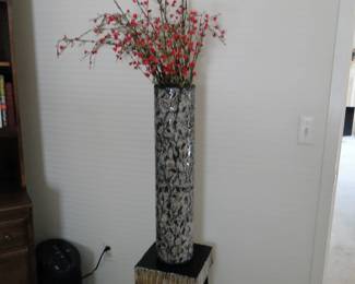 Tall cylindrical vase, on short squatty table. It works