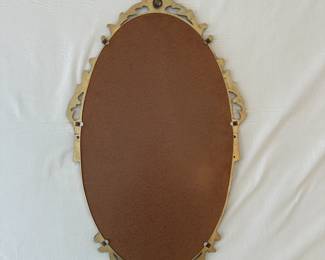 R17 - $95. Ornate Gold Gilt Oval Wall Mirror. Frame is metal.  Made in England etched in the back. Measures 15.5" wide x 26" tall.