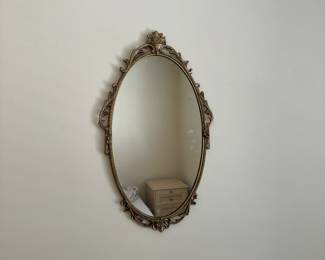 R17 - $95. Ornate Gold Gilt Oval Wall Mirror. Frame is metal.  Made in England etched in the back. Measures 15.5" wide x 26" tall.