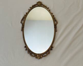R17 - $95. Ornate Gold Gilt Oval Wall Mirror. Frame is metal.  Made in England etched in the back. Measures 15.5" wide x 26" tall.