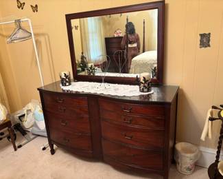 Vintage Mahogany Dresser with Mirror, clothing rack with hangers, and a compact, foldable desk pedal, small Vintage bedroom trash can.