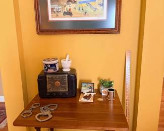 Vintage radio, handcuffs, mortar and pestle, collectibles on wood side table