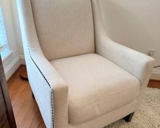 Cream upholstered accent chair with nailhead trim