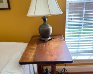 Ceramic table lamp with white shade on wood side table