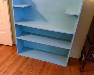 a light blue 3-tier bookcase, designed with open shelving for storing books or displaying decorative items. 