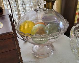 vintage glass compote dish with a lid features a crystal-clear design, a faceted knob handle, and a scalloped rim
