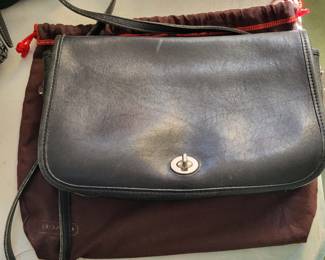 vintage Coach leather pocket purse, featuring brass hardware, a full-length exterior slip pocket, and a detachable strap for versatile wear. 