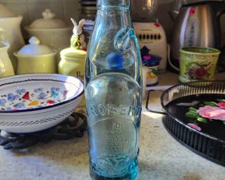 Vintage J. Roberts Castleford Codd bottle, manufactured in England during the late 19th century. These bottles are designed with a marble and rubber seal inside the neck to hold carbonation without a traditional cap. 
