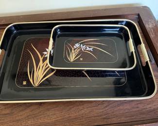 vintage Japanese Toyo lacquerware nesting serving trays featuring a black finish with a floral design and contrasting handles. 