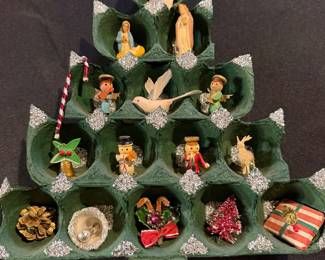 vintage, handmade Christmas advent calendar made from painted egg cartons, featuring a Nativity scene and other small ornaments housed in the compartments. 