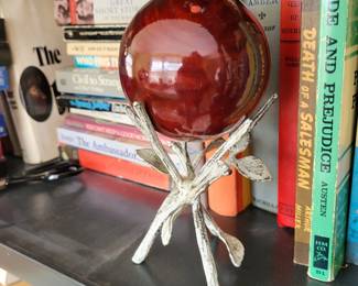 vintage decorative orb, likely glass or stone, displayed in a wrought iron holder. 