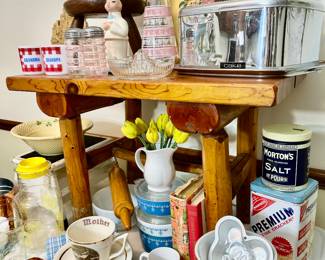 Rustic log bench loaded with vintage kitchen items.