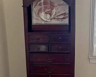 Tall dark wood accent cabinet with Asian-inspired styling. Features a display shelf on top, multiple small drawers with ring pull hardware, larger drawers with bail pulls, and lower cabinet storage. Solid wood, great condition. Works well in a bedroom, entryway, or living room. Approximately 5’ tall, 2’ wide. (Art for Sale Separately)