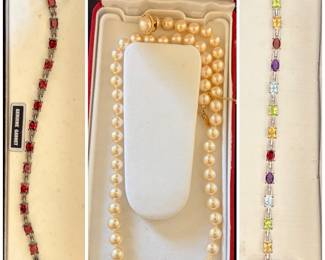 A collection of jewelry including a garnet bracelet, a classic pearl necklace, and a multi-colored gemstone bracelet.