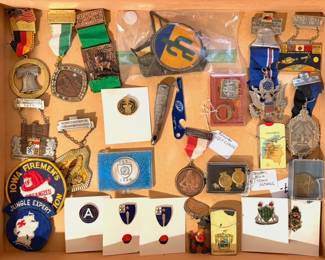 A collection of vintage pins, medals, and awards.