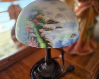 Thomas Kinkade reverse painted glass table lamp, featuring coastal or harbor scenery painted on the underside of the shade. 