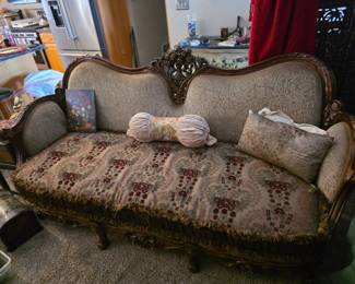 

This vintage couch appears to be in the Victorian style, likely featuring Rococo Revival elements such as intricate wood carvings and upholstered floral fabric. 