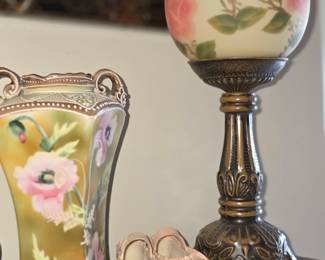 This antique-style, hand-painted glass globe candle holder features a floral rose design on a detailed, ornate bronze-tone pedestal base. 