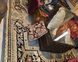 traditional style area rug, featuring intricate floral patterns and a dark border, likely made of wool and handcrafted. 