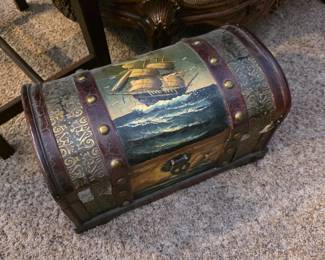 This item is a decorative treasure chest featuring a vintage nautical painting of a ship on the lid. 
Design: Often constructed with a wooden or faux-leather finish, accompanied by antique-style hardware, hinges, and corner brackets. 