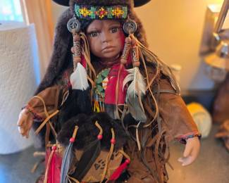 This item is a "Maiden Warrior" porcelain doll from the Timeless Collections limited series. 
It is designed for sitting display and is approximately 14-20 inches tall. 