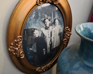 vintage oval picture frame featuring a gold finish and intricate ornate details, commonly known as a Victorian-style bubble glass frame. 
Style: Features a convex or "bubble" design glass and embossed floral or leaf motifs. 