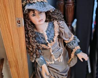 vintage porcelain collectible doll, featuring detailed Victorian-style clothing. 