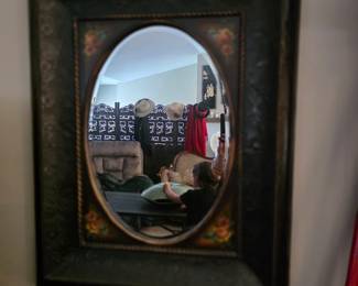 This item is a decorative oval wall mirror, likely with a wood or MDF frame featuring painted floral accents similar to the OVALCREST style. 