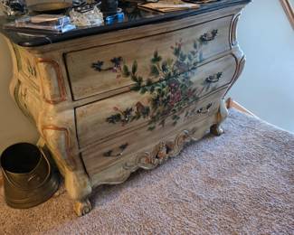 19th-century Italian Venetian Rococo style hand-painted bombe commode. The chest features a curved front, ornately painted floral details, and aged decorative hardware. 