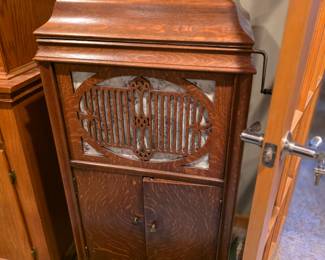 Brunswick phonograph, likely from around 1918. 
Design: It features an oak cabinet with decorative front speaker paneling and a crank handle on the side for manual winding. 
Functionality: Brunswick phonographs of this era were designed to play three types of records: standard lateral shellac (78s), vertical cut shellac (Pathe), and vertical cut Diamond Discs (Edison). 
Unique Feature: The reproducer, known as the "Ultona," can be rotated to accommodate different types of needles and stylus points to play these varied record formats. 
Storage: The cabinet typically includes interior compartments for storing disc records. 