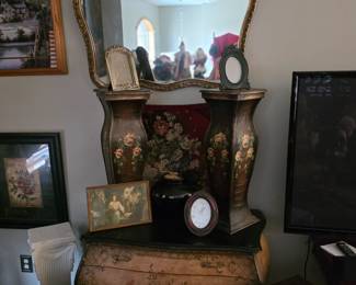 19th-century Italian Venetian Rococo style hand-painted bombe commode. The chest features a curved front, ornately painted floral details, and aged decorative hardware. 

-Late 20th Century wooden floral column featuring a black base with handpainted pink and yellow floral designs.
Pedestal or column planter.