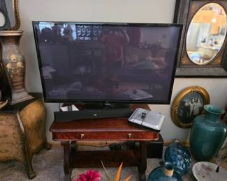 1.flat-screen television
2. traditional wooden writing desk featuring drawers with brass
