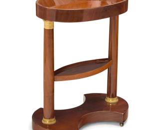 334 A Louis Philippe mahogany table Second quarter 19th century The tiered table with columnar supports and gilt-bronze capitals and bases, raised on brass casters 26.5" H x 21.75" W x 13" D Estimate: $400 - $600
