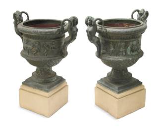 433 A pair of large Baroque style cast metal garden urns 20th century Each with opposed mermaid handles and decorated with classical figures and beasts in relief, with lining to interior, raised on a concrete base 2 pieces Each planter: 32" H x 31.5" W x 22.25" D; Each base: 12" H x 16.75" W x 16.75" D Estimate: $1,000 - $1,500