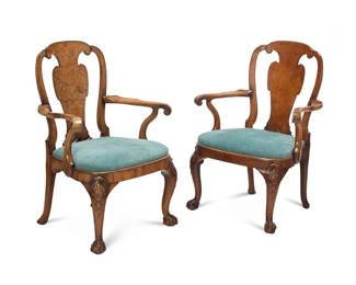 313 A pair of George I/II style walnut veneered armchairs Circa 1900 Each with vasiform burlwood veneered splat, modified shepherds crook armrests terminating in scrolls, later upholstered seat cushion, raised on cabriole legs headed by carved shell and bellflower ornament, ending in claw and ball feet 2 pieces Each: 40" H x 29.75" W x 25" D Estimate: $300 - $500