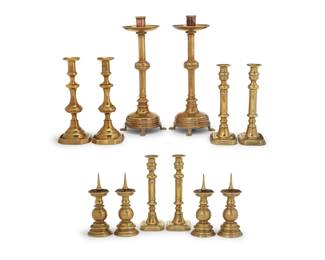 367 A group of brass candlesticks 19th-20th century Comprising a tall pair raised on paw feet, a set of four with rectangular bases, a pair with squared bases, and a set of four pricket sticks, each with weighted base 12 pieces Tallest: 17.5" H x 5.75" Dia.; Prickets: 9.25" H x 3.5" Dia. Estimate: $600 - $800