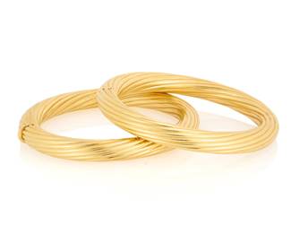 57 A pair of 18K Gold Bangles Of a twisted high polish hinged design 2 pieces  Measures: 6 3/4 in. 108.2 grams Estimate: $7,000 - $10,000