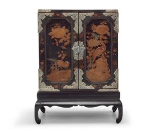379 A Japanese black lacquered wood table cabinet 20th century Mounts XRF tested for .990 silver The small cabinet mounted with chased silver and painted with foliate motifs throughout, the hinged doors painted with phoenixes and opening to reveal eight drawers, all raised on a conformingly mounted and decorated stand Cabinet: 15.5" H x 14.25" W x 9.75" D; Overall: 21" H x 16" W x 11" D Estimate: $500 - $700