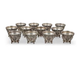 262 A set of twelve French silver open salts 20th century Impressed: M.G. [over three stars in a diamond lozenge]; XRF tested .940 The rim with flowerheads over the body cast with four roundels enclosing the head of a bishop holding a cross and raising his hand in blessing, separated by male term supports 12 pieces Each: 2" H x 2.625" Dia. Total weight: 52.2 oz. troy approximately Estimate: $2,000 - $3,000