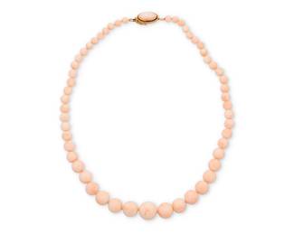 17 An 18K Gold and Coral Necklace Of a single strand design featuring graduated round coral beads measuring approximately 6.31 - 16.72 mm, finished with an 18k gold and coral clasp  Length: 22 1/2 in. 84.4 grams gross Estimate: $1,500 - $2,000