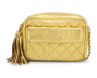 153 CHANEL: A Metallic Gold Quilted CC Pocket Camera Bag Stamped to interior: Chanel / ® / Made in Italy A vintage rectangular gold lurex fabric/leather crossbody bag with exterior flap pocket, large fringe CC tassel, gold tone hardware, metallic leather chain strap, and zip top closure, and with brown smooth leather interior and one zip pocket with brown satin lining  5 1/2 in. H x 7 3/4 in. W x 2 1/4 in. D; strap drop: 20 in. Estimate: $500 - $700