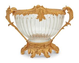 384 A Louis XV style gilt bronze and glass center bowl Late 20th century Unmarked The lobed glass bowl mounted with gilt-bronze foliate-form handles, rim accents, and base 15.25" H x 21.5" W x 18" D Estimate: $1,500 - $2,000