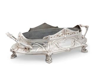 207 A Jugendstil silver plated jardinière Early 20th century Unmarked With opposed handles and metal liner, decorated with repoussé ribbon-work and foliate motifs, raised on six feet 5.75" H x 20.25" W x 11.25" D Estimate: $300 - $500