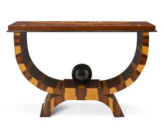 332 An Art Deco style exotic wood hall table Late 20th century The top with inlaid circular motifs above stacked curved supports accented by a central ball finial 32" H x 49" W x 16.5" D Estimate: $1,000 - $2,000