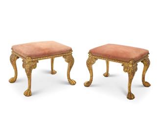 369 A pair of George II style giltwood stools 20th century Each with pink suede leather upholstered seat cushion with brass tacking, raised on legs carved with acanthus leaves and paw feet 2 pieces Each: 20" H x 25.5" W x 21.5" D Estimate: $500 - $700