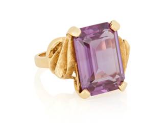 114 A 14K Gold and Synthetic Color-Change Sapphire Ring Centering an emerald-cut synthetic color-change sapphire weighing approximately 15.60 carats  Size: 8 1/4 10.8 grams gross Estimate: $400 - $600