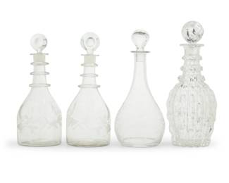 314 A group of four clear glass decanters Mid/late 20th century One etched: Val St. Lambert Comprising one pair with frosted etched 'John Carson' (each: 11.25" H x 4.5" Dia.), one Val St. Lambert decanter with frosted scroll motif (11.625" H x 5.125" Dia.), and another decanter with ring neck and thumbprint lobed body (12.5" H x 5.125" Dia.), each with stopper 4 pieces Estimate: $300 - $500