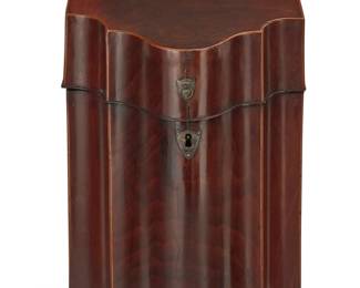 362 A George III inlaid mahogany knife box Late 18th/early 19th century Later converted to a tantalus, the box with marquetry shell to hinged locking lid, opening to reveal an updated fitted interior housing three glass liquor bottles with stoppers and six shot glasses Box: 15" H x 9" W x 10.75" D; Larger bottles: 8.5" H; Shot glasses: 2.125" H Estimate: $700 - $900